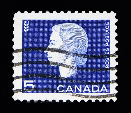 MOSCOW, RUSSIA - MAY 13, 2018: A stamp printed in Canada shows Queen Elizabeth II, wheat sheaf, Definitives serie, circa 1962のeditorial素材