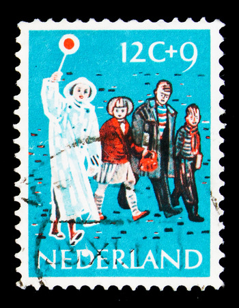 MOSCOW, RUSSIA - MAY 16, 2018: A stamp printed in Netherlands shows Lollipop man guiding children, Children Stamps - Year of the Disabled serie, circa 1959のeditorial素材