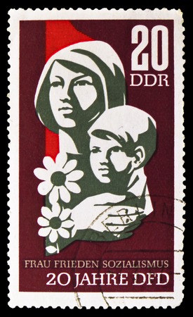 MOSCOW, RUSSIA - SEPTEMBER 15, 2018: A stamp printed in DDR (Germany) shows Woman and child, 20 Years Of Democratic Women's Federation Of Germany serie, circa 1967のeditorial素材