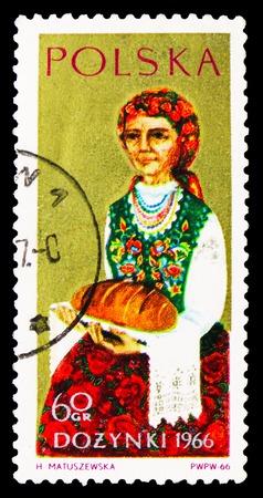MOSCOW, RUSSIA - SEPTEMBER 15, 2018: A stamp printed in Poland shows Woman holding loaf of bread, Harvest Festival serie, circa 1966のeditorial素材