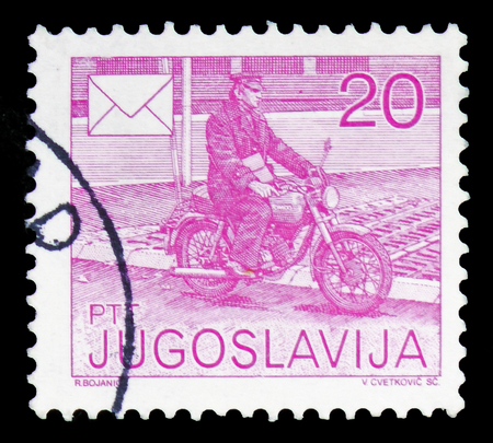 MOSCOW, RUSSIA - FEBRUARY 10, 2019: A stamp printed in Yugoslavia shows Mailman on motorcycle, Postal Services serie, circa 1986のeditorial素材