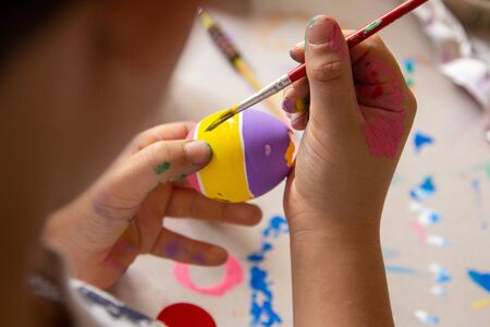 right hand Kid painting Eastern eggs