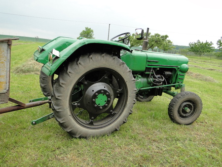 Harvest of hay with tractor in the gardenの写真素材