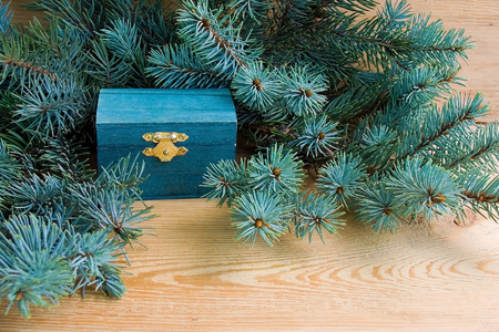 Natural style of christmas background with wooden chest and spruce branches on a wooden background. Front view.の写真素材