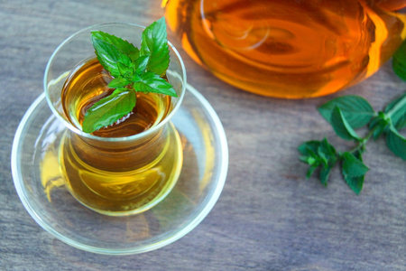 Fresh healthy peppermint tea in a transparent glass. Green mint leaf. Organic. Front view.の写真素材