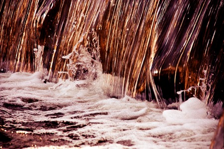 Vivid bright splashes of falling water from a waterfall or fountain. Isolated, duotone. Front view
