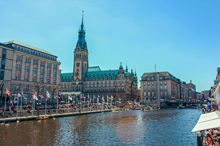 A picturesque lake Alstersee in the central historical district Roterbaum of Hamburg, Germany.June 2010. People on the steps of the stairs fed swans, ducks, geese. Popular vacation spot, health trailのeditorial素材