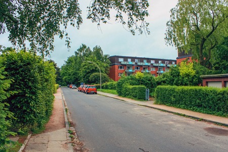 District of Altona, Hamburg, Germany in june 2010. Free road in a residential area between houses with cars, green grass, bushes and treesのeditorial素材