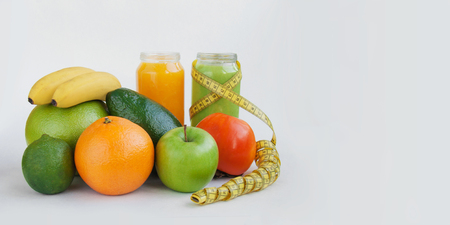 Creative background smoothie juice persimmon,lime,suite,avocado,apple,orange banana tape measure white paper.の写真素材