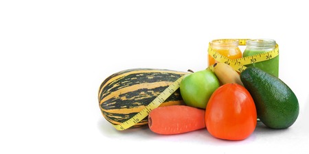 Creative background smoothie juice summer fruits vegetables. Avocado,apple, carrot banana persimmon zucchini tape measure white paper.の写真素材