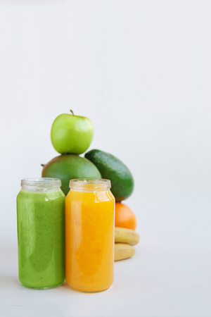 Creative background smoothie juice summer fruits. Avocado,apple banana orange mango isolated on white paper.の写真素材