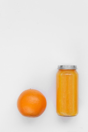 Creative background bottle of freshly squeezed orange juice with whole orange isolated on white paper.の写真素材