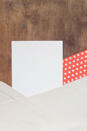 Beautiful background of paper of color living coral polka dot and white with a beige plaid on a wooden background with copy space for text.の写真素材