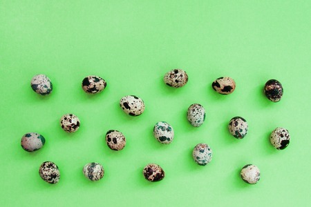 Bright frame with perfect Easter quail eggs on pastel mint background with copy space for text. Flat lay, close up, top view, horizontal. Card concept.の写真素材