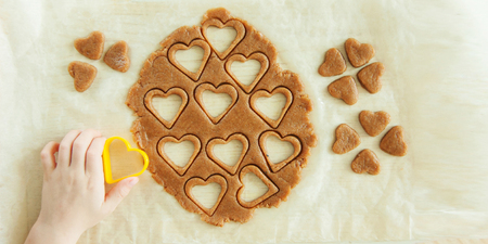 Young child hands is preparing the dough, bake cookies dessert, biscuit, gingerbread in the kitchen....