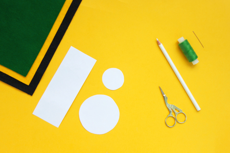 Tutorial how to sew felt leprechaun hat for St. Patrick's day. Concept of DIY sewing art project. Step by step photo instruction. Top view, copy space. Step 1 paper patternの写真素材