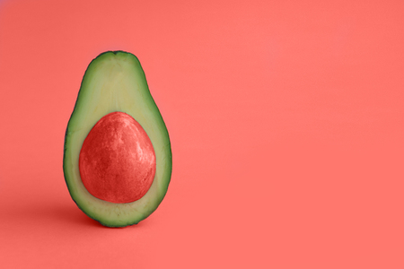 Beautiful creative decoration trendy background idea with fresh green avocado with coral bone. A...