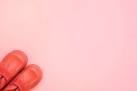 Small childrens shoes fashionable living coral color on a bright background with an empty place for the inscription. Top view, copy space.の写真素材