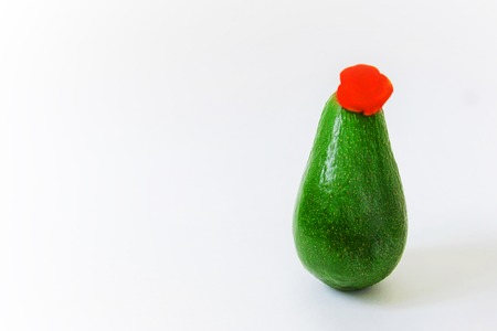 Slender fresh green avocado with a flower hat like an elegant woman. Minimal original vegan concept...