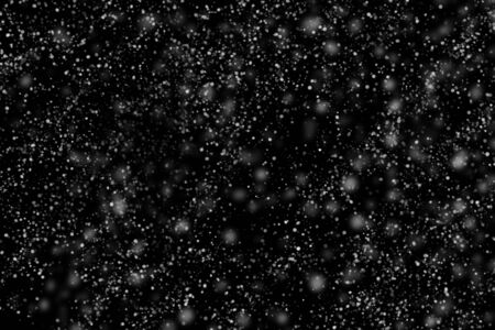Texture of white snow during a snowfall on a black background for use when editing winter photos to create an atmosphereの写真素材