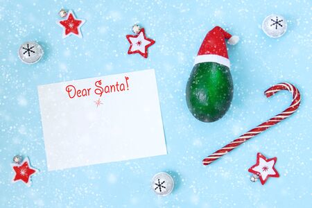 Christmas decorations and sweets scattered from knitted striped cap elf. Candy cane,  tree, bells with snowflakes, stars. Creative Christmas card concept with copy space for text. Flatlayの写真素材