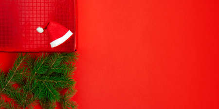 Christmas decoration background with fresh natural branches of Christmas tree spruce on red paper background. Card concept. Closeup. Top view. Flat lay. Copy spaceの写真素材