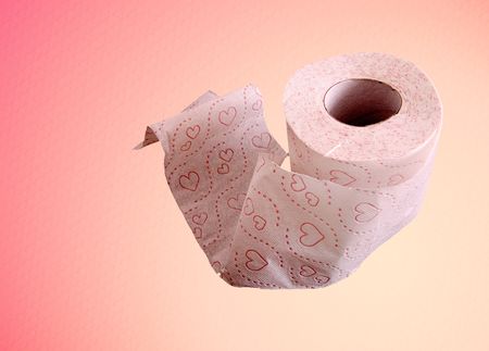 A roll of toilet paper on a pink background.の写真素材