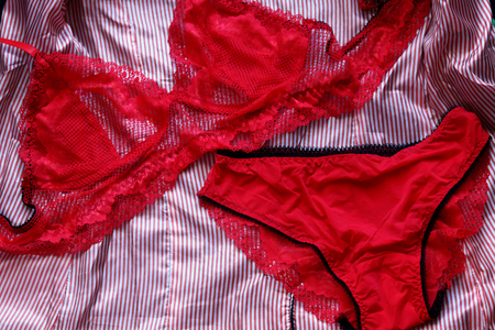 lace handmade underwear. Sexy red women's lace underwear, a set of bra and panties on a striped background. close-upの写真素材