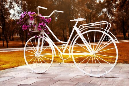 Floral bike - artistic floral design, street decoration. Charming street decoration - old bike with flowersの写真素材