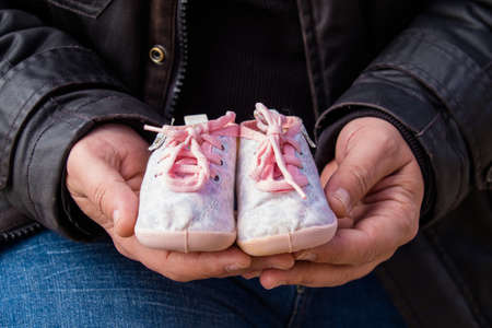 Expecting father holding their future baby bootsの写真素材