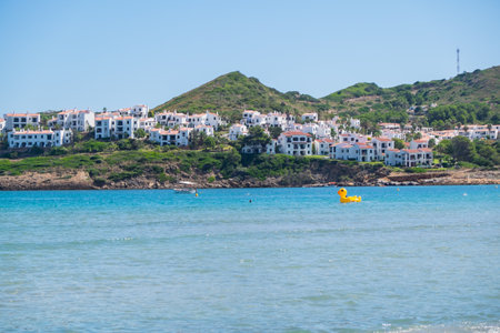 Menorca, Spain - August 6, 2020: Nice bay with an inflatable mega yellow duck, Cala Tirant, Fornells, Menorca, Balearic Islands. Spain.のeditorial素材
