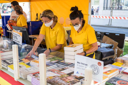 Tarragona, Spain - July 23, 2020: People looking at books with mask and hydroalcoholic gel during Sant Jordi feast in Tarragona, Catalonia.のeditorial素材