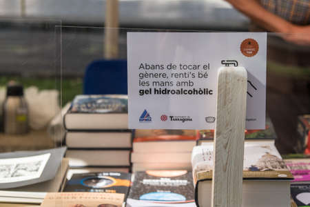 Tarragona, Spain - July 23, 2020: People looking at books with mask and hydroalcoholic gel during Sant Jordi feast in Tarragona, Catalonia.のeditorial素材