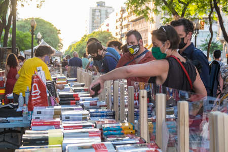 Tarragona, Spain - July 23, 2020: People looking at books with mask and hydroalcoholic gel during Sant Jordi feast in Tarragona, Catalonia.のeditorial素材