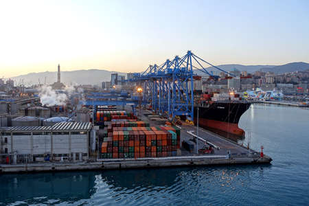 Genova, Italy: Cranes and containers in the cargo terminal of the commercial harbor in Genoa, one of Europe's busiest shipping ports. The iconic Lanterna lighthouse can be seen in the backgroundのeditorial素材