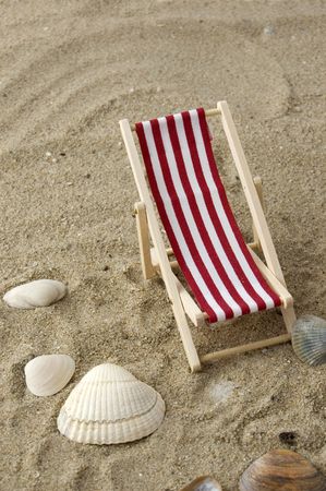 beach chair on the sand surrounded by shellsの写真素材