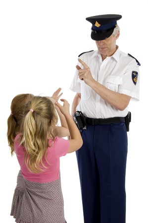 Fully dressed dutch police officer is warning two little girls who are making long nose の写真素材