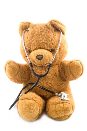 Bown teddybear acting as a doctor with a stetoscope isolated on whiteの写真素材