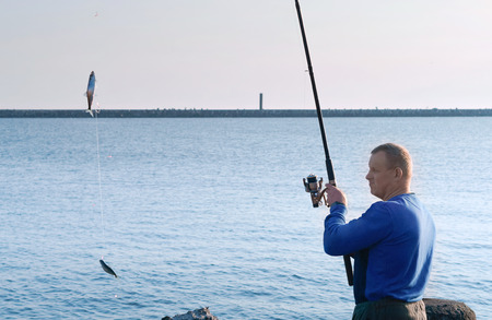 a man caught a fish on a fishing rod, fishing on a Salak, fishing in the evening, sea fishing in the...