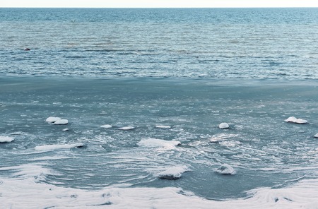 crumbled ice floats in the water, ice sludge in the sea, the sea does not freeze in winterの写真素材