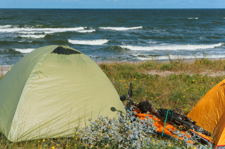 cyclists camping, tourist tent on the beach, camping with tents in the summerの写真素材