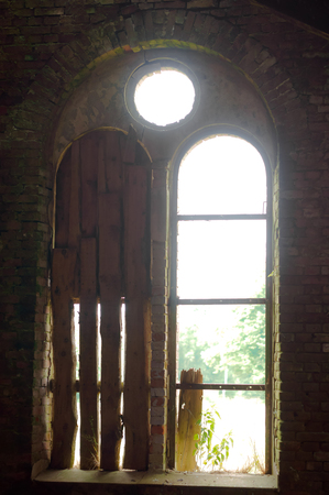 broken window of an old building, old red brick building, Church in the village of Zapovednoye (Seckenburg), Kaliningrad region, Russiaの写真素材