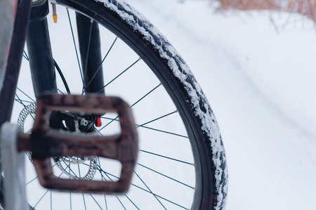 bike in winter, Bicycle wheel on snow-covered road backgroundの写真素材