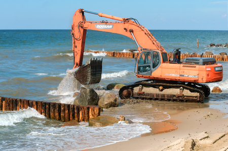 construction of breakwaters, construction equipment on the sea coast, Baltic sea, Kaliningrad region, Russia, July 15, 2018のeditorial素材