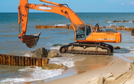 construction of breakwaters, construction equipment on the sea coast, Baltic sea, Kaliningrad region, Russia, July 15, 2018のeditorial素材