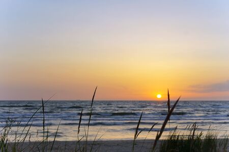sunset on the seashore, the sky is purple from the sunsetの写真素材