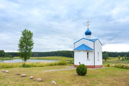 a small chapel on the lake, white Church with a blue roof, Krasnolesye village, Nesterovsky district, Kaliningrad region, Russia, Eastern Europe, 31 July 2019のeditorial素材