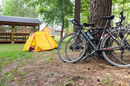 cyclists tourists camping, two bicycles and a yellow tourist tent, Marinovo village, Nesterovsky district, Kaliningrad region, Russia, August 1, 2019のeditorial素材