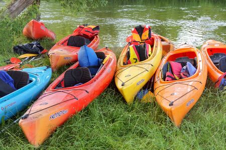 colorful kayaks at the pond, eight kayaks on the shore of the river, Angrapa river, Kaliningrad region, Russia, June 15, 2019のeditorial素材