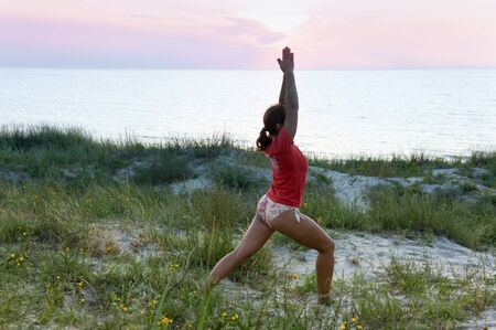 girl doing exercises at sea, girl warming up on the seashore, Kaliningrad region, Russia, Baltic sea, July 20, 2019のeditorial素材